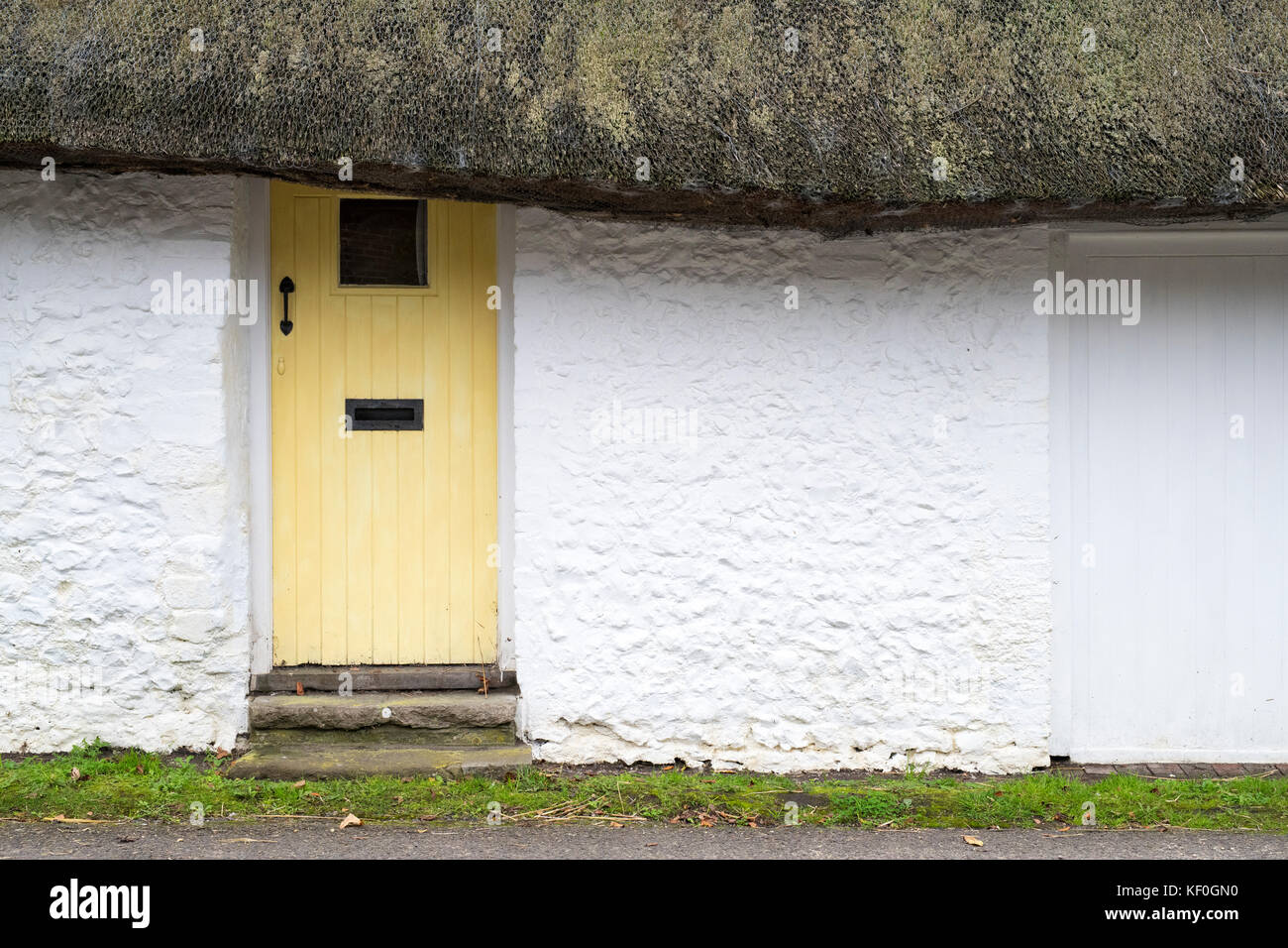 Yellow wooden front door in a thatch cottage in Singleton, West Sussex, England Stock Photo