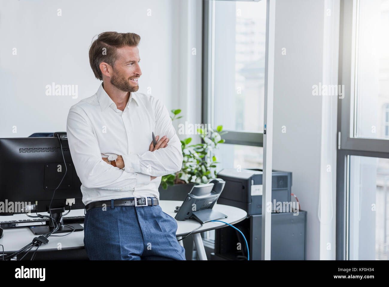 Portrait of smiling businessman with arms crossed in the office Stock ...