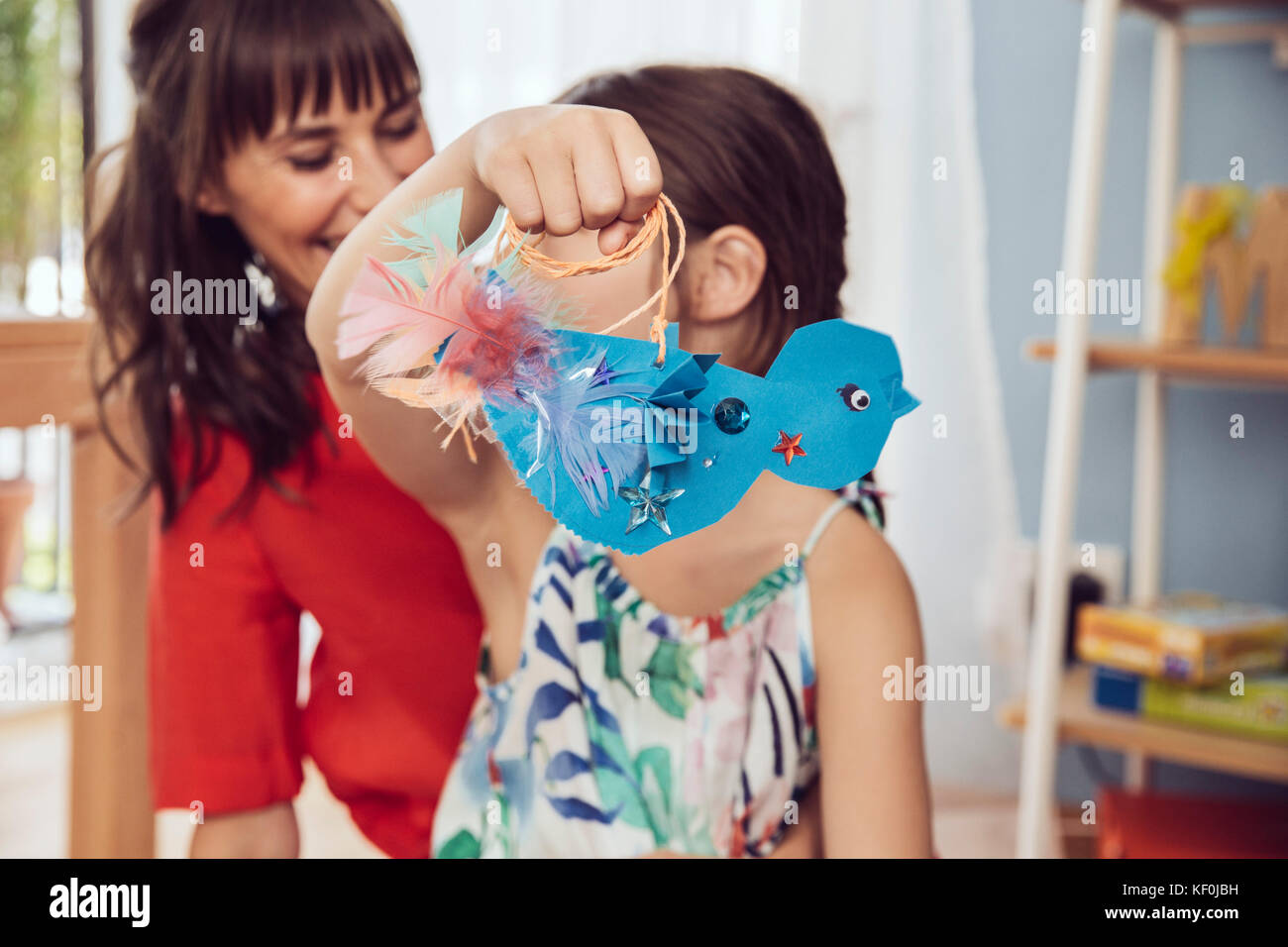 Mother and daughter playing with self-made paper bird Stock Photo