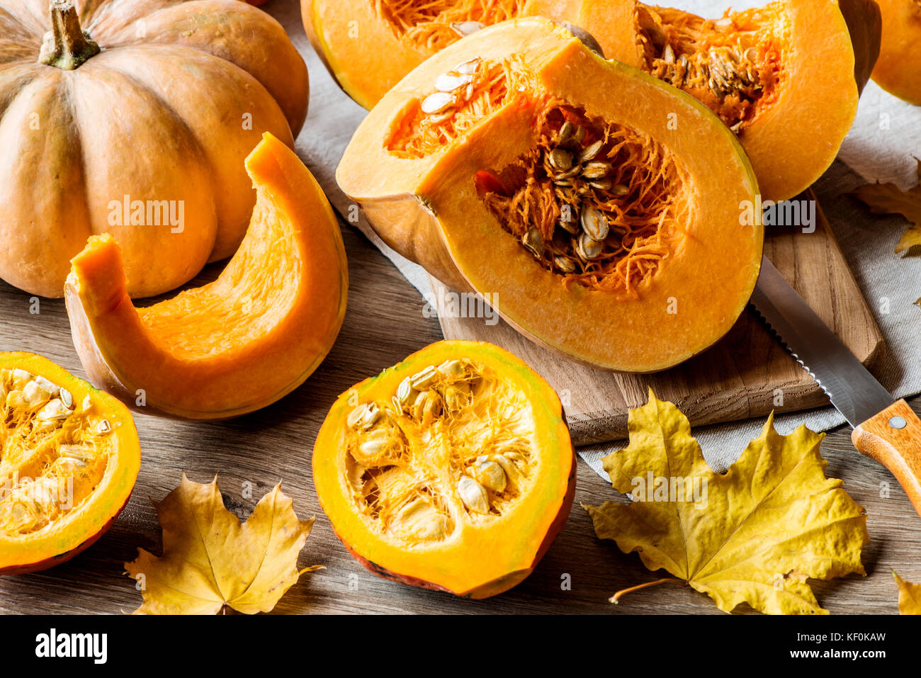 Sliced pumpkin with seeds on a wooden background. Close-up Stock Photo