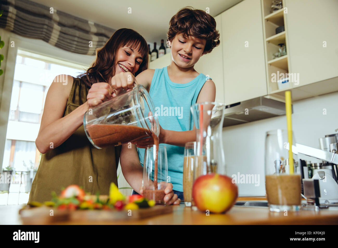 Mother and son pouring smoothie into glass Stock Photo