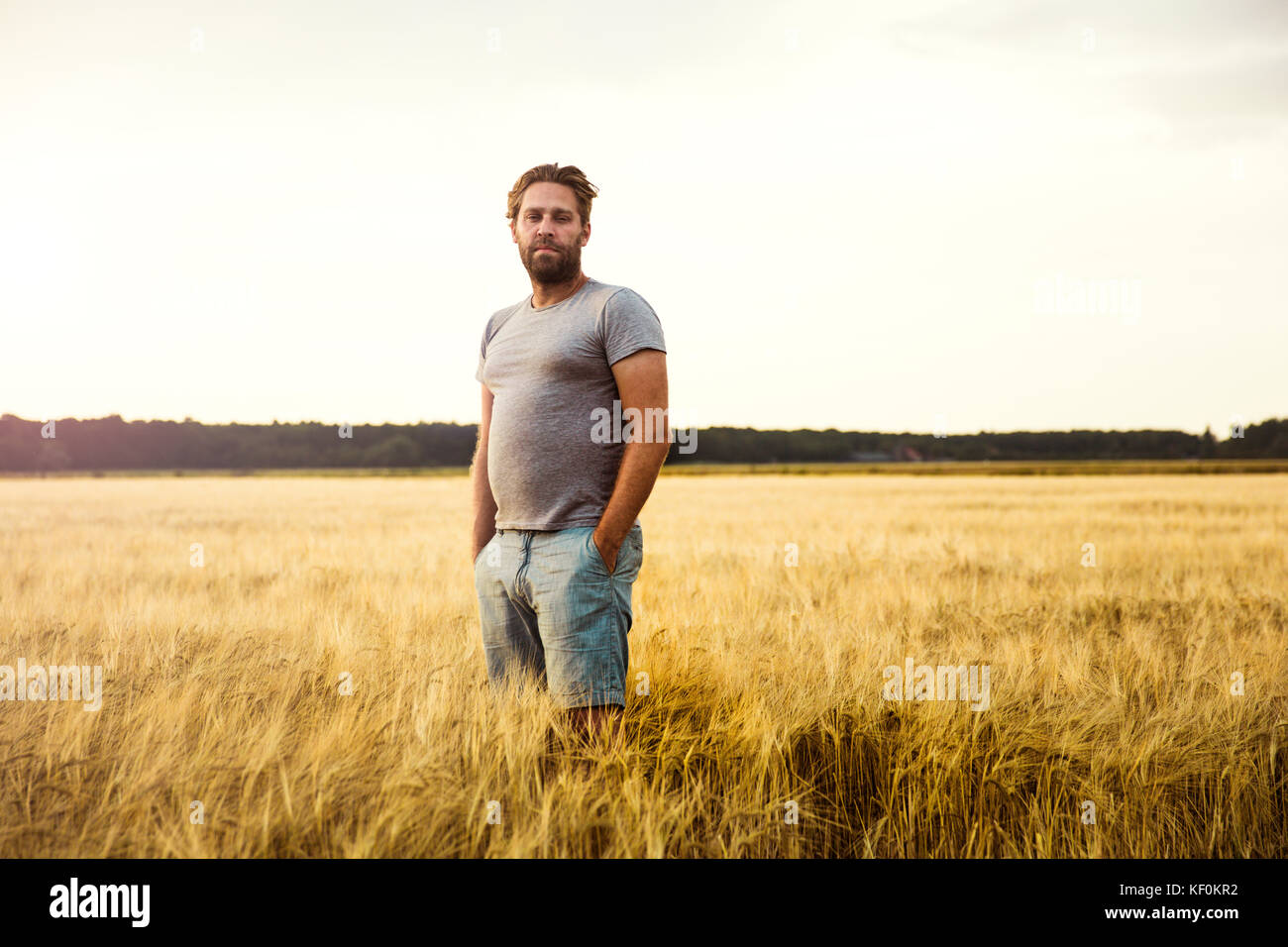 Man standing in grain field Stock Photo - Alamy