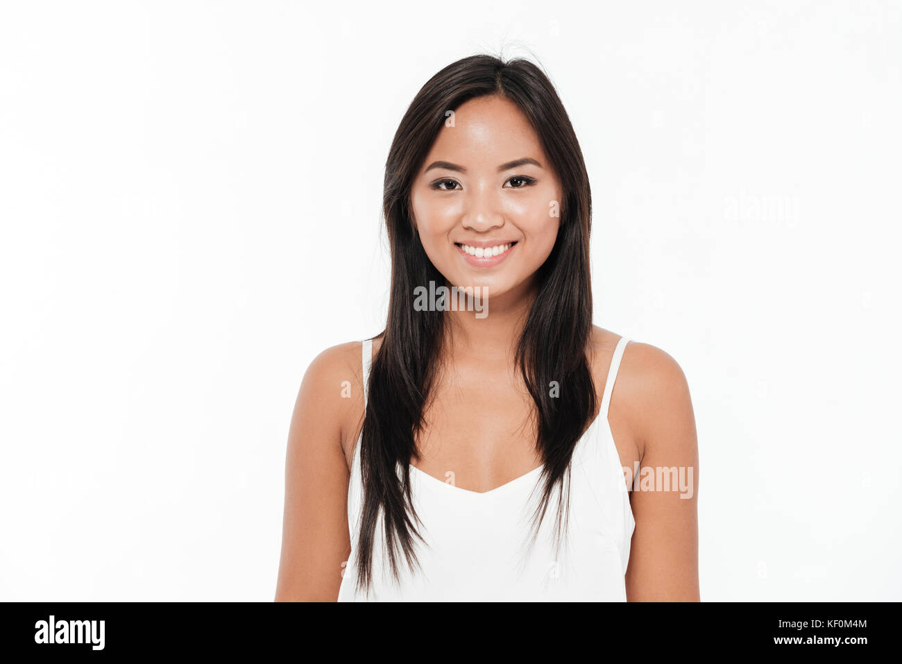 Portrait of a happy young asian woman looking at camera isolated over ...