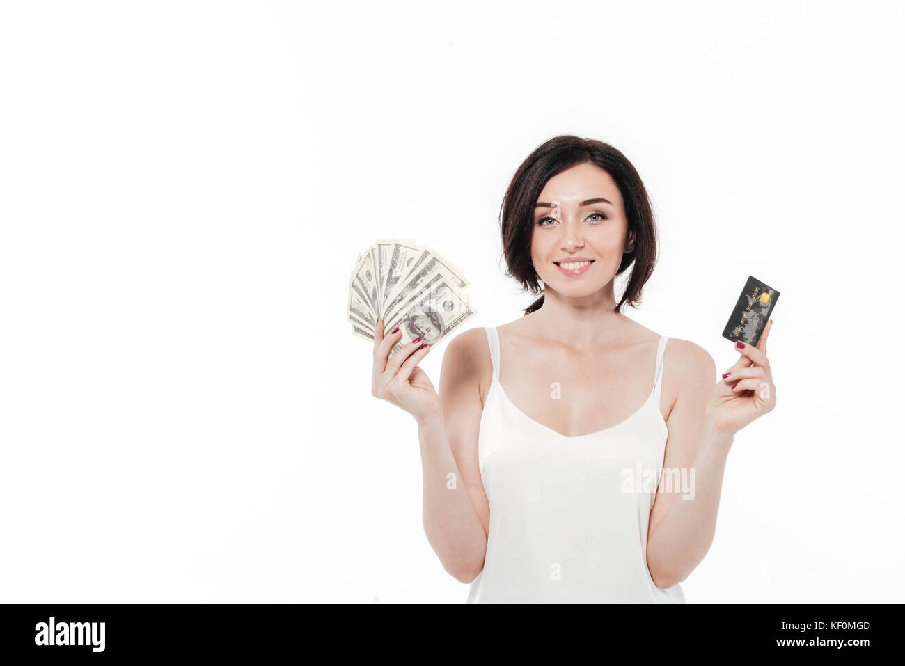 Portrait of a pretty smiling woman showing bunch of money banknotes and a credit card with copy space isolated over white background Stock Photo