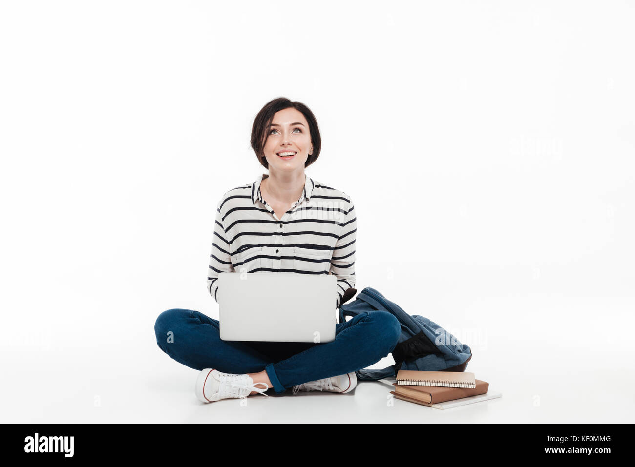 Portrait of a happy teenage girl with backpack holding laptop computer ...