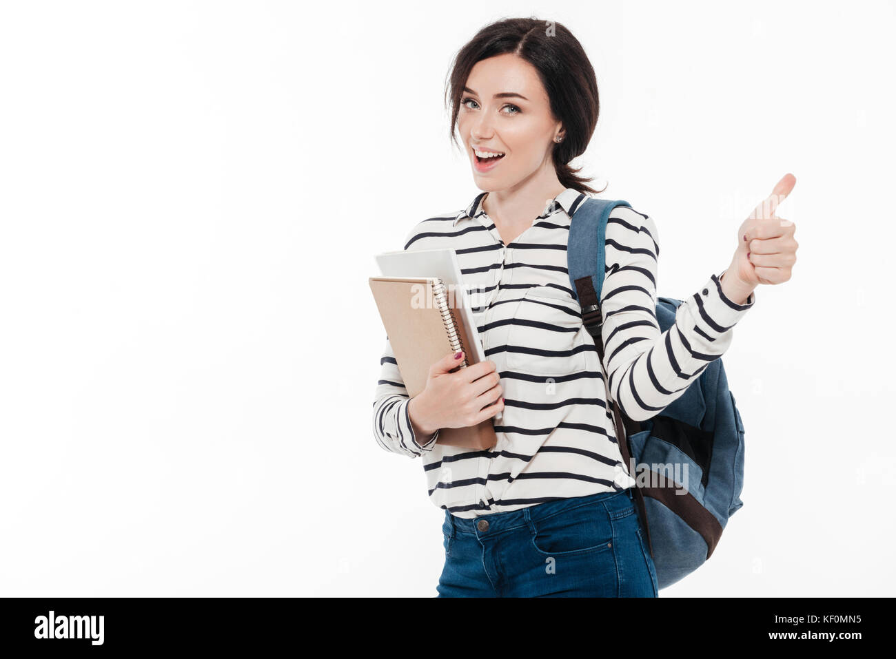 Portrait of a happy teenage girl with backpack holding books while ...