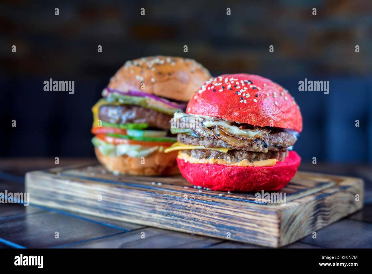 Two different restaurant burgers on wooden board Stock Photo
