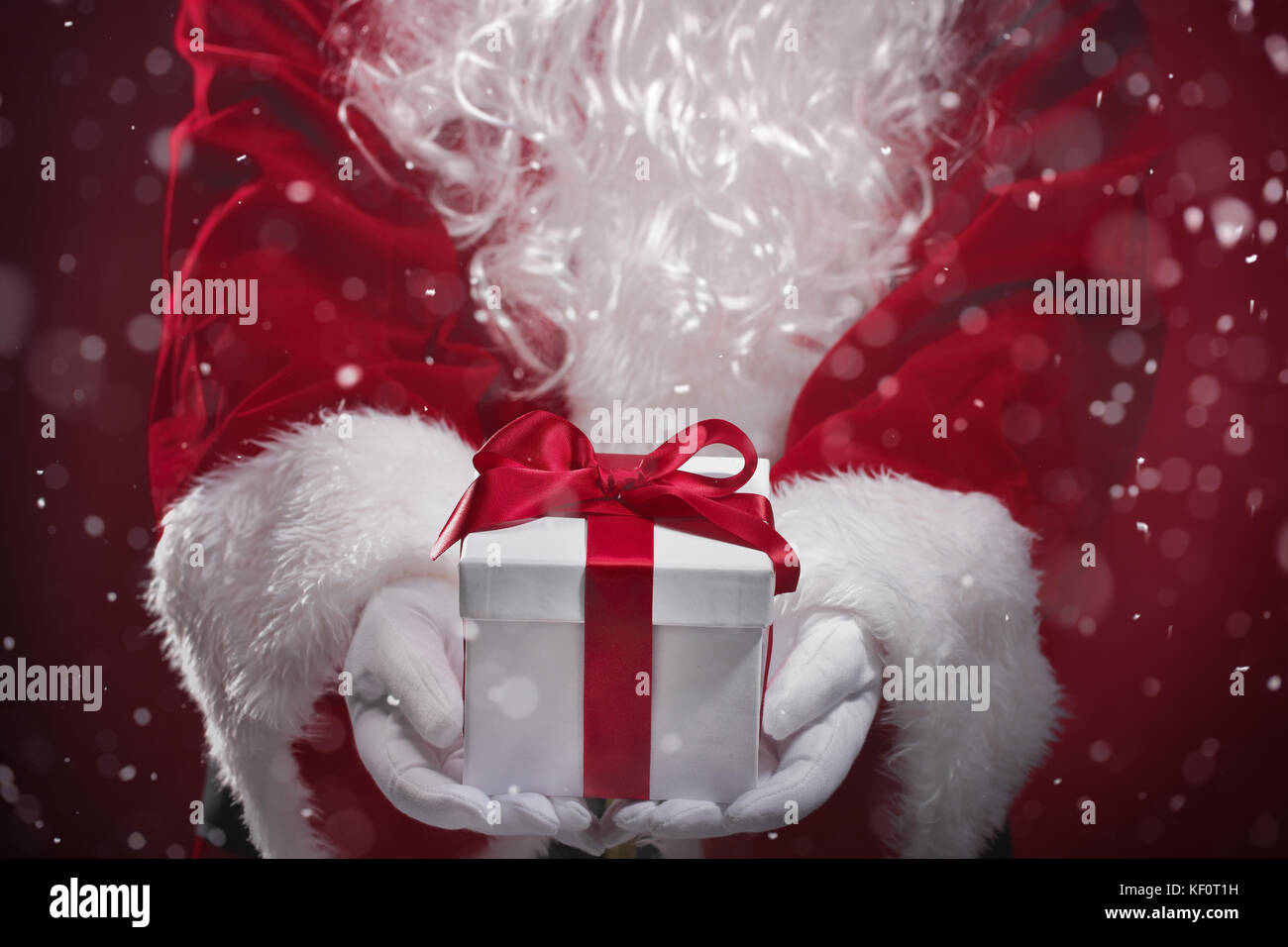Santa Claus holding gift boxes in snow Stock Photo