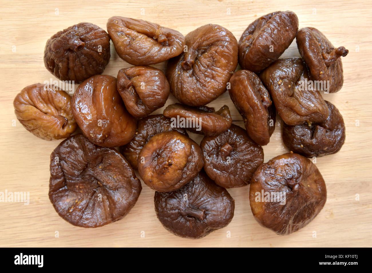 Overhead view of partially rehydrated dried figs on chopping board