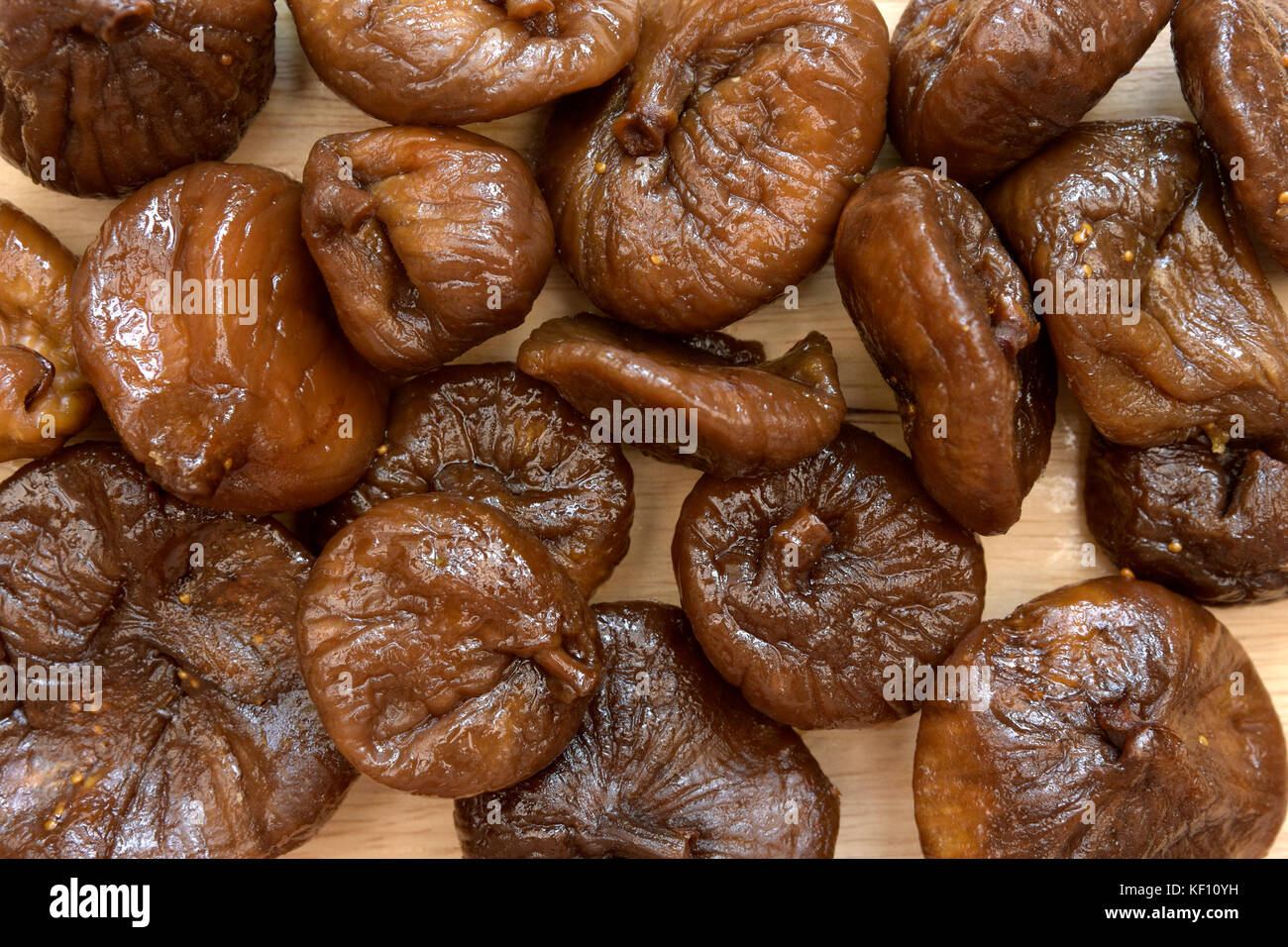 Overhead view of partially rehydrated dried figs on chopping board