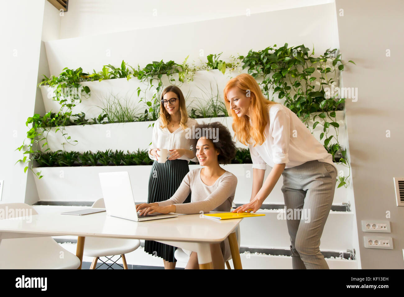 Three young businesswomen working together in the office Stock Photo ...