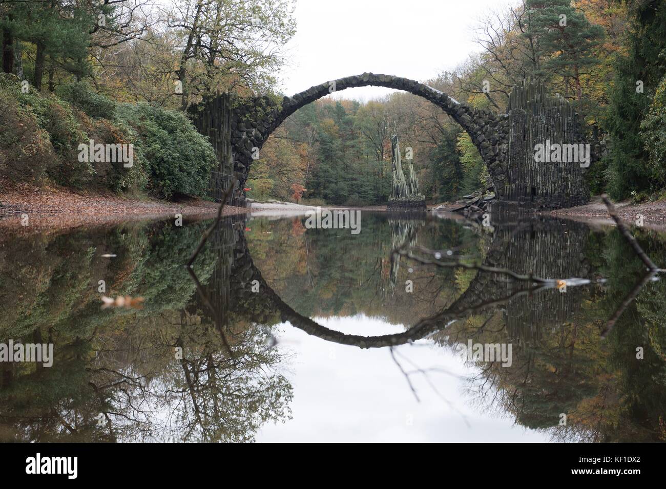 Kromlau, Germany. 25th Oct, 2017. The Rakotz bridge is reflected in a