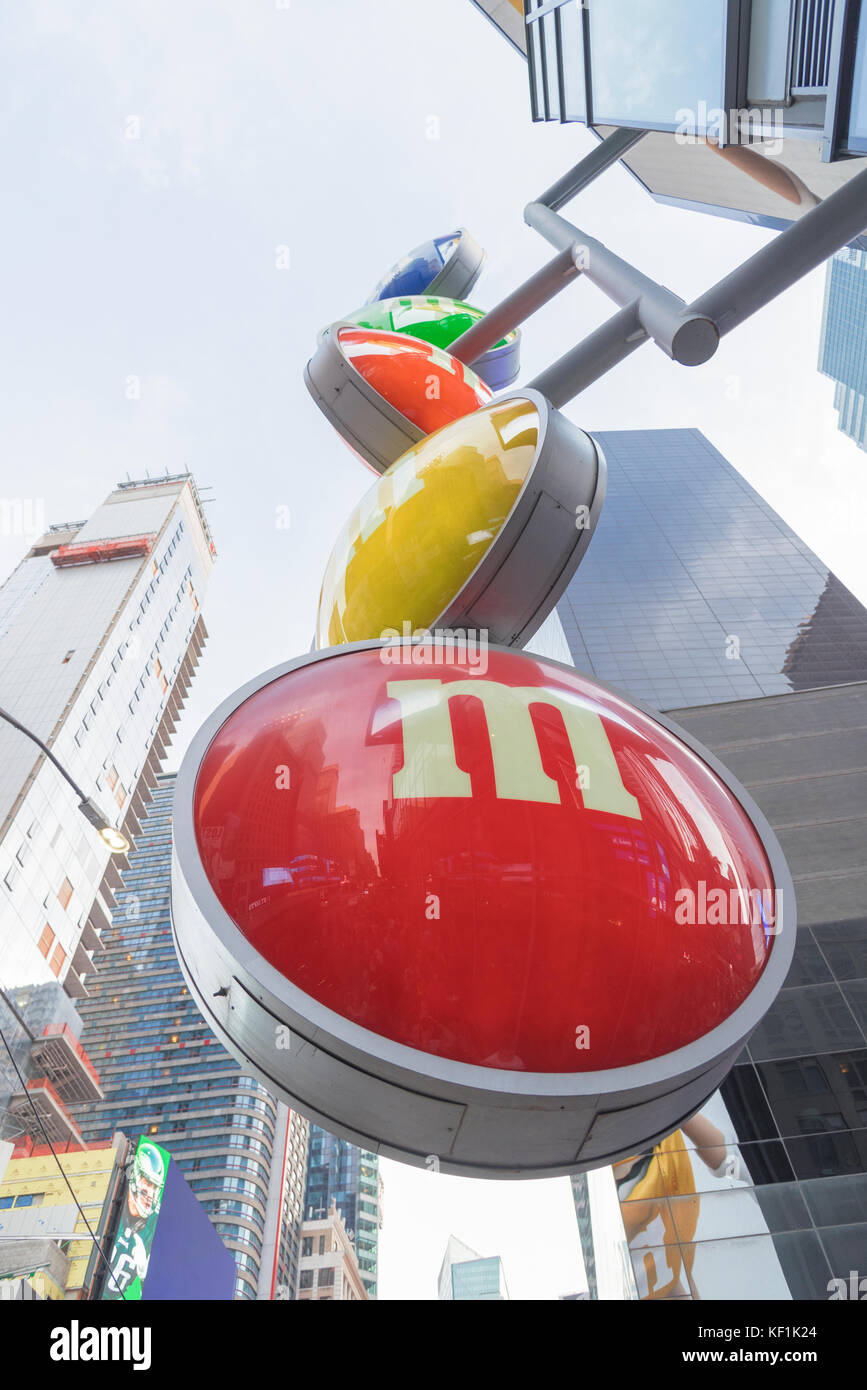 Portrait looking up at the m&m store sign in New York Cities Times Square shopping district during the daytime. Stock Photo
