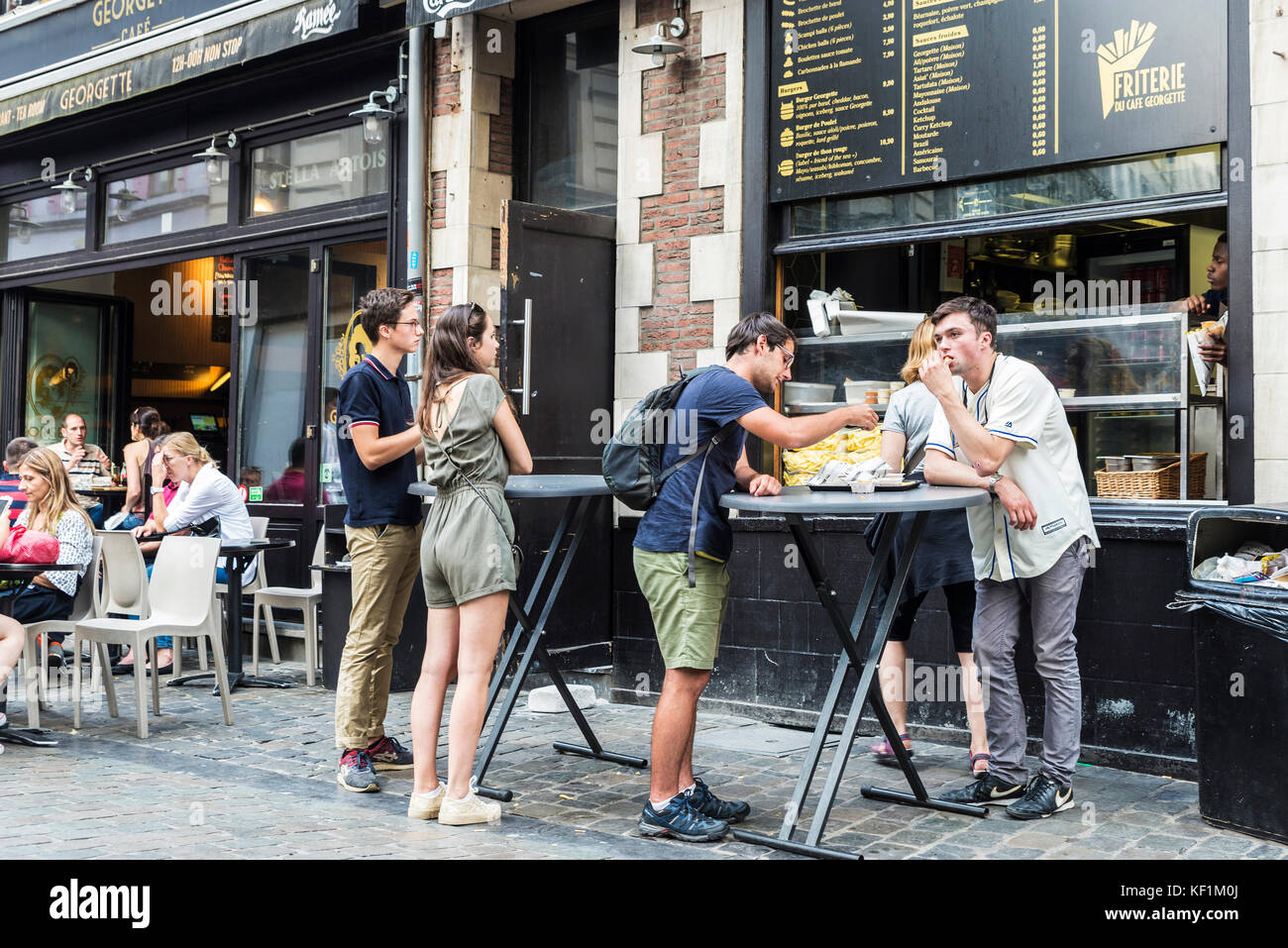 Brussels, Belgium - August 26, 2017: People eating french fries in a bar on the street in Brussels, Belgium Stock Photo