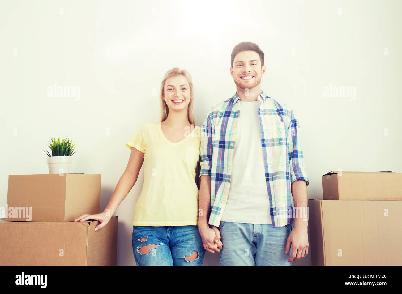 smiling couple with big boxes moving to new home Stock Photo - Alamy