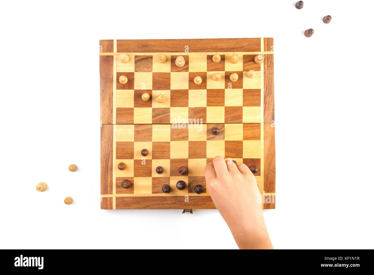Chess board with chess pieces and a kid hand Stock Photo