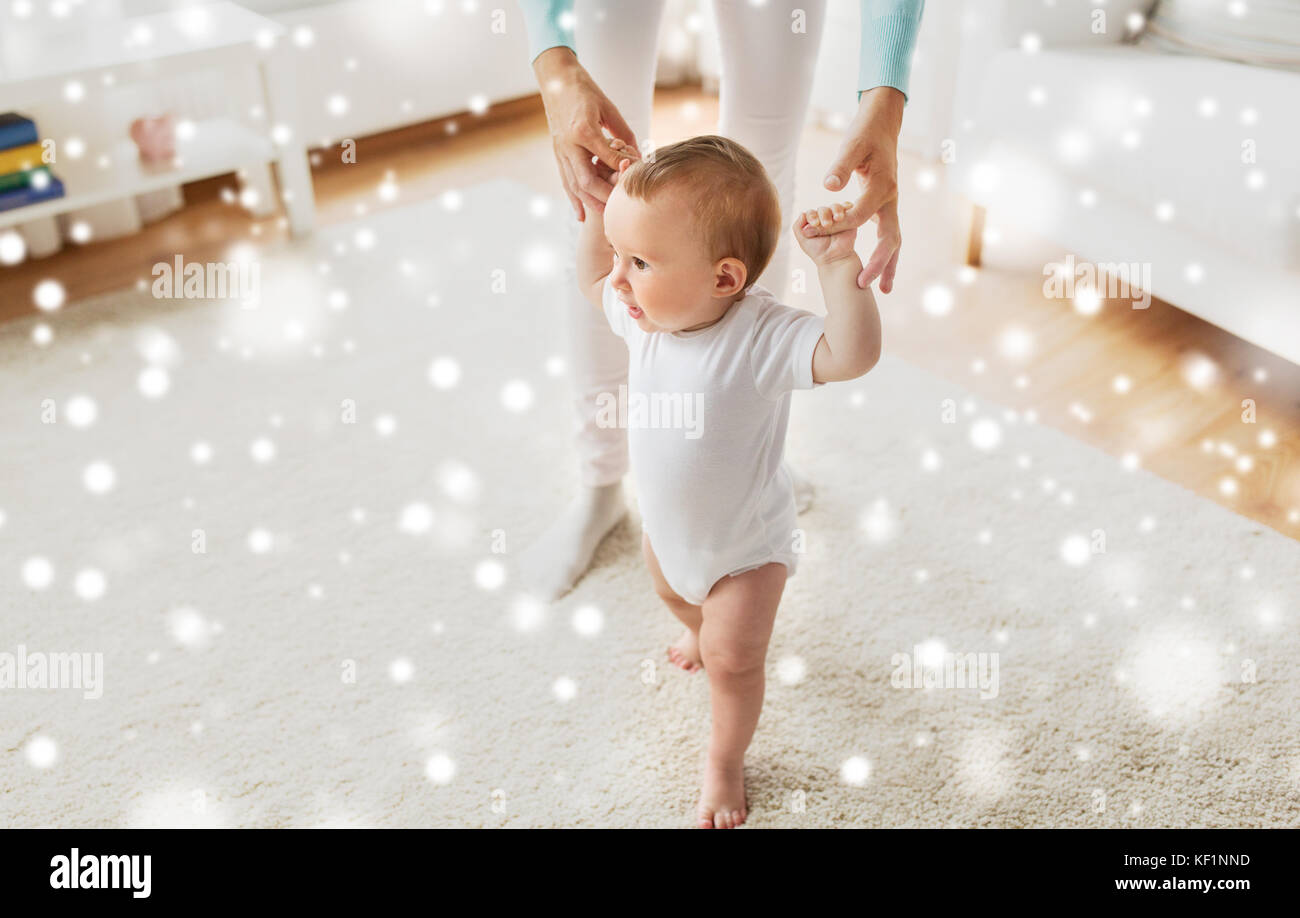 happy baby learning to walk with mother help Stock Photo