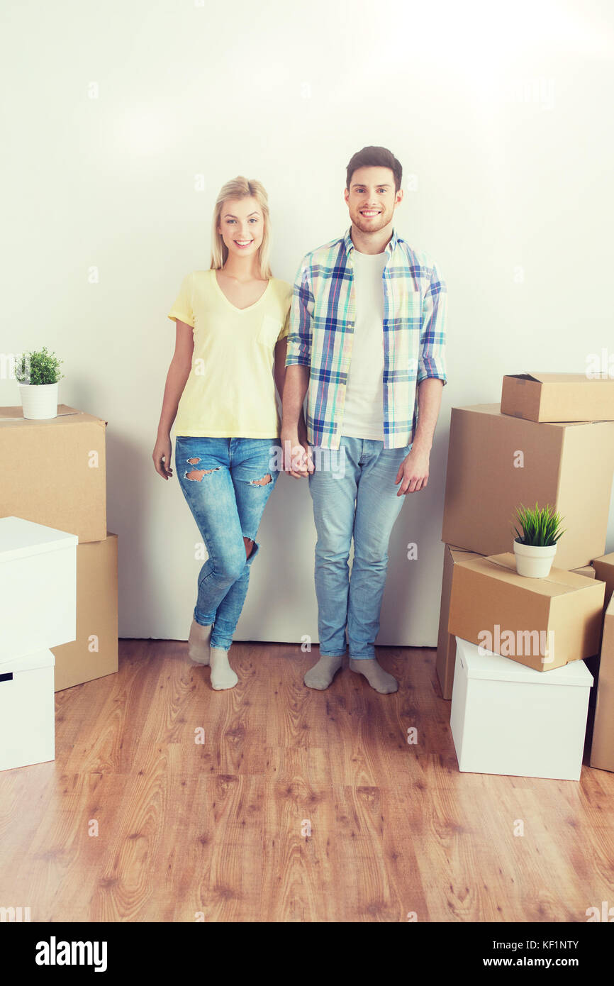 smiling couple with big boxes moving to new home Stock Photo - Alamy