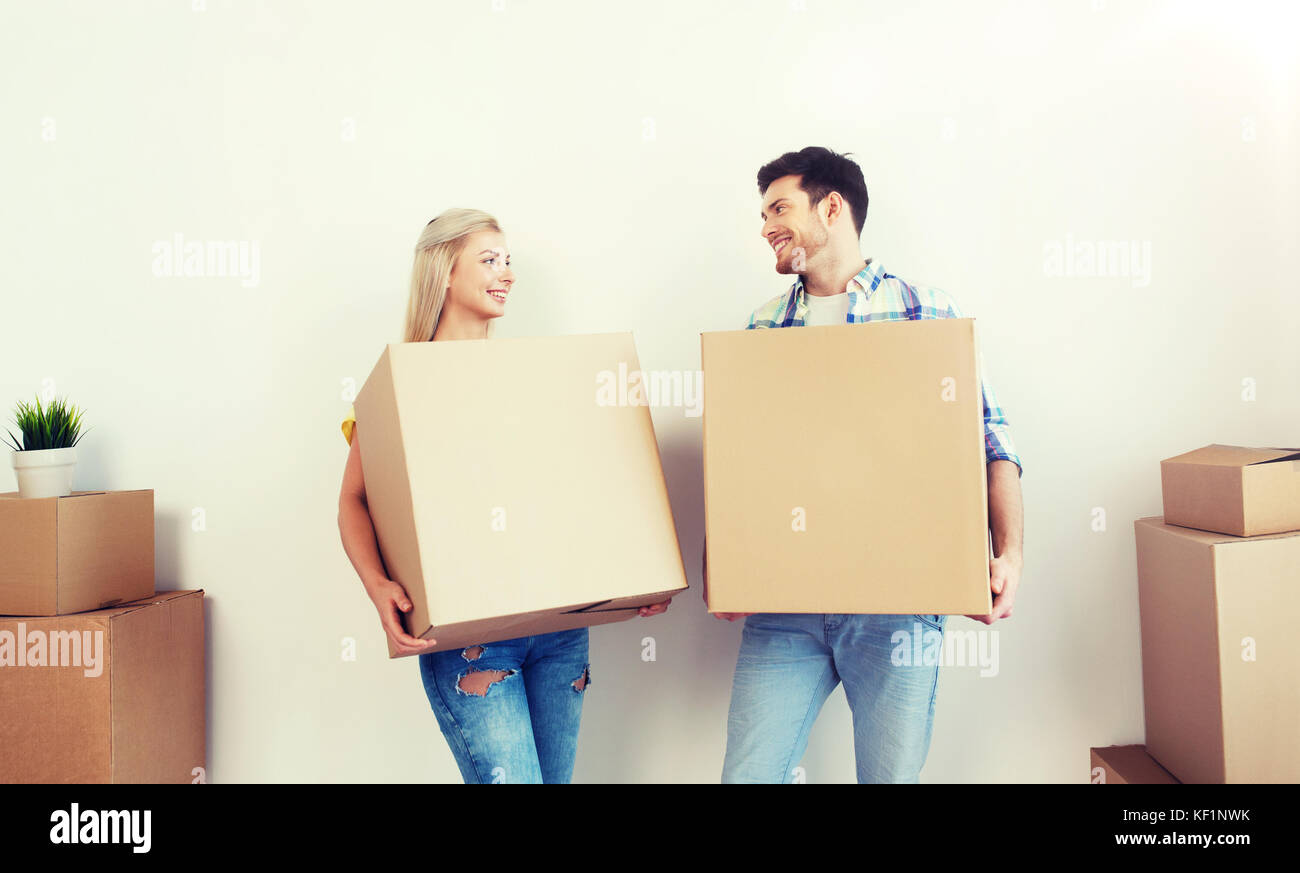 smiling couple with big boxes moving to new home Stock Photo - Alamy