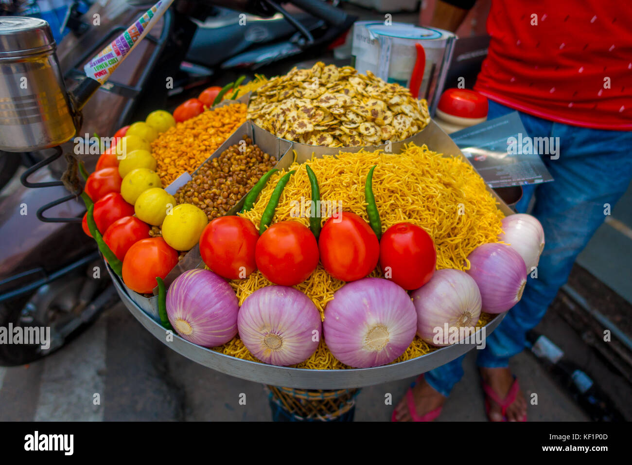 JAIPUR, INDIA - SEPTEMBER 19, 2017: Close up of assorted food, tomato, onion, noddle, chili, pepper over a plastic tray in a public market in the street in Jaipur, Rajasthan Stock Photo