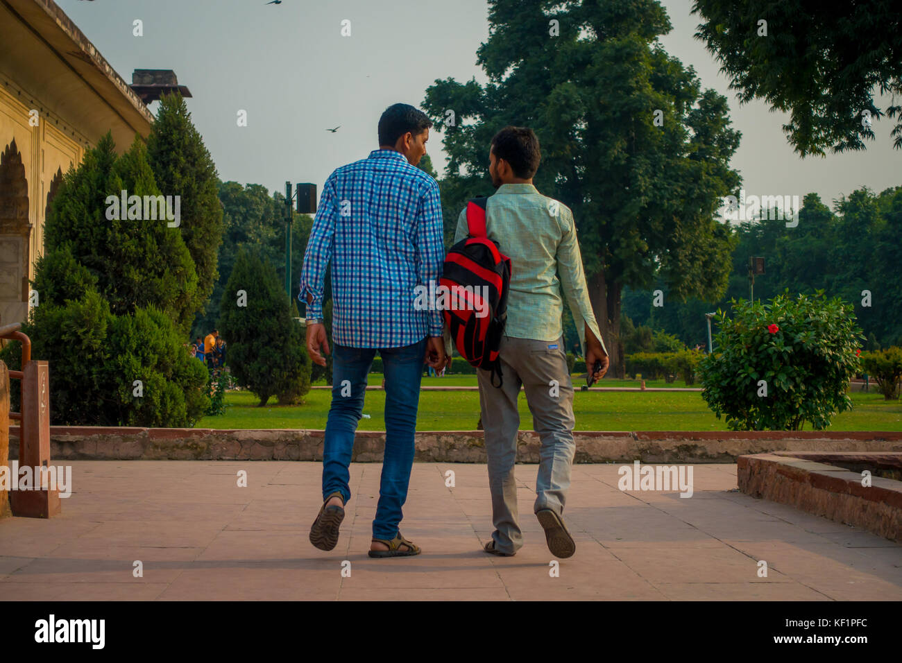 DELHI, INDIA - SEPTEMBER 25 2017: Unidentified gay couple holding their hands and walking around Inlaid marble, columns and arches, Hall of Private Audience or Diwan I Khas at the Lal Qila or Red Fort in Delhi, India, fish eye effect Stock Photo