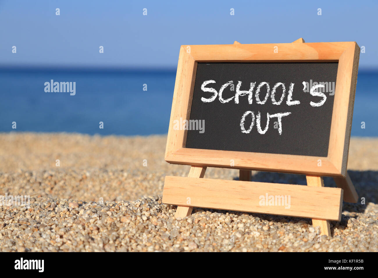 Blackboard with School's out text on the beach Stock Photo