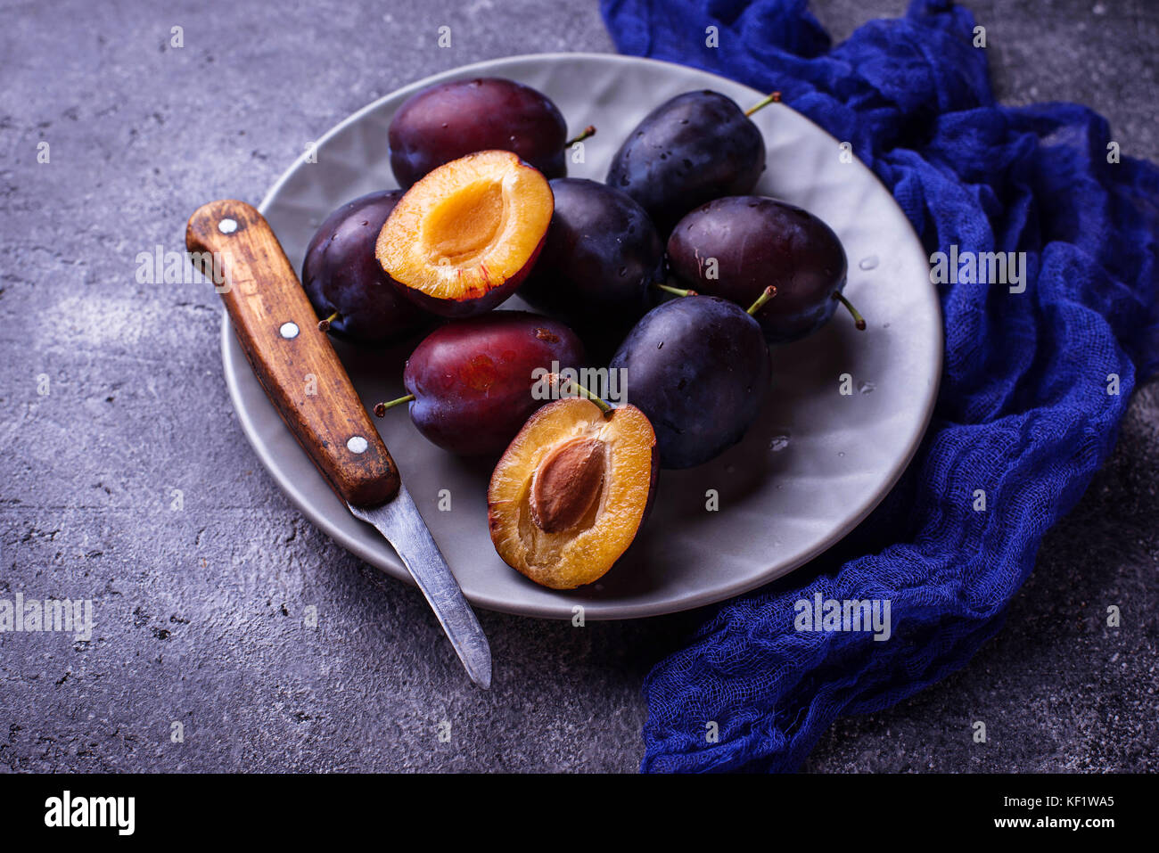 Fresh sweet plums on concrete background Stock Photo Alamy