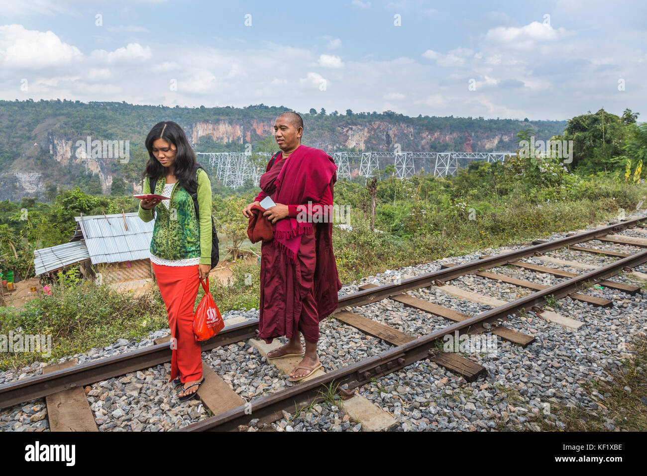 Monk and young woman on the railway line at the Goteik (Goke Hteik) viaduct, a railway trestle in Nawnghkio between Pyin Oo Lwin and Lashio, Myanmar Stock Photo