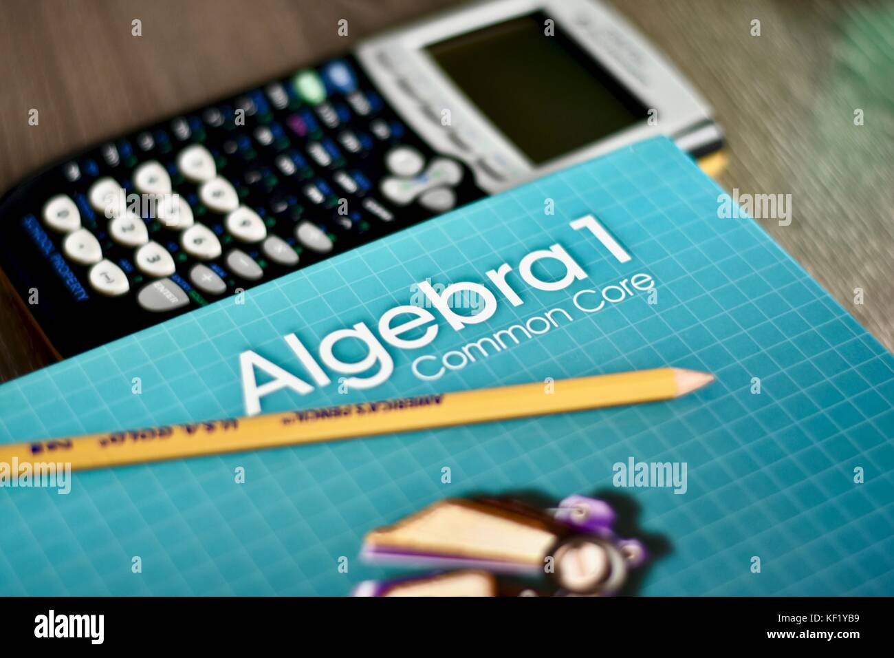 Algebra math book on desk next to classroom materials Stock Photo
