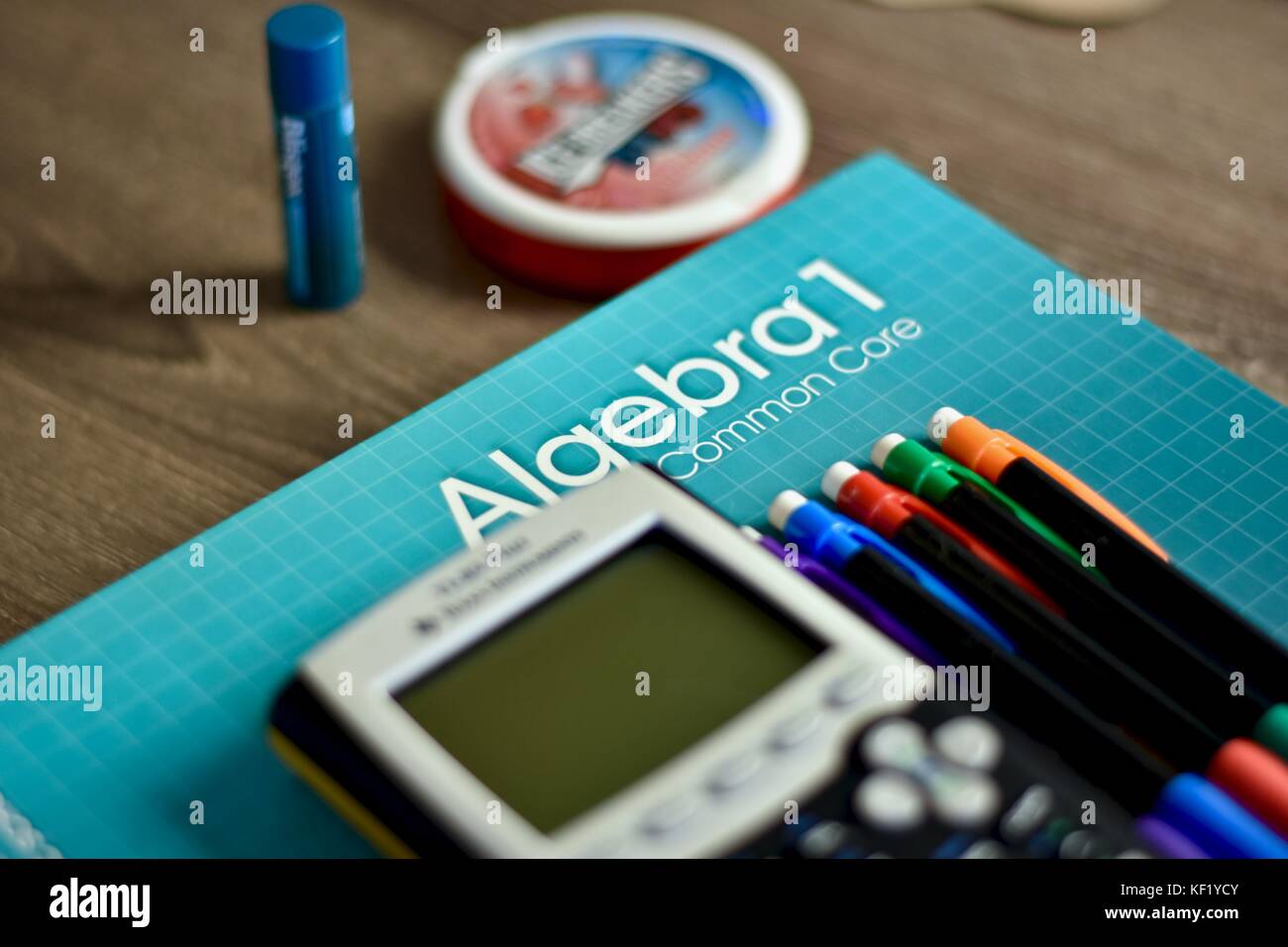 Algebra math book on desk next to classroom materials Stock Photo