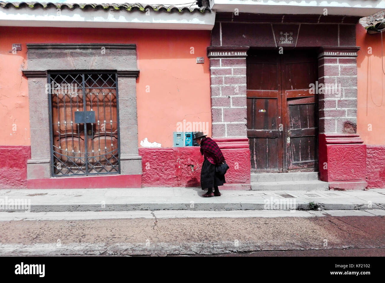 Old woman walking in front of a tradtional house on Ayacucho streets Stock Photo