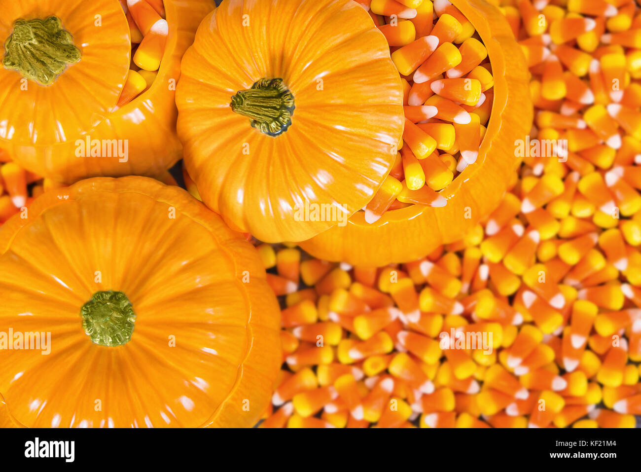 Ceramic decorative pumpkins filled with Halloween candy corn. Top view