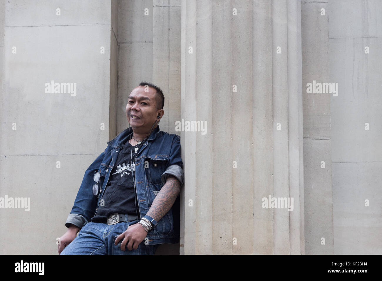 An Asian man smoking and leaning on Stock Photo