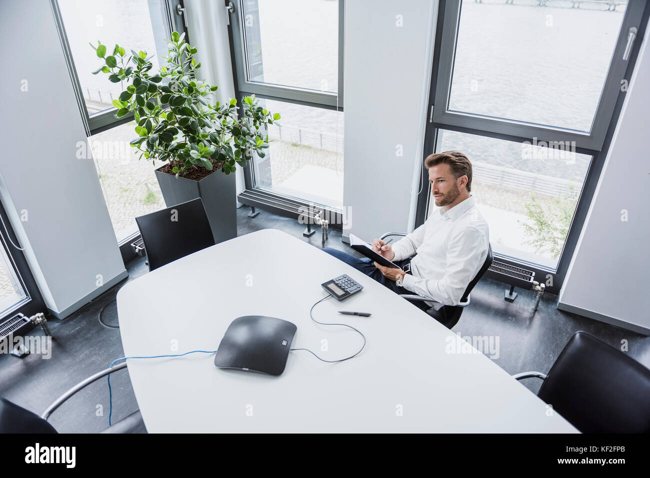 Businessman sitting at meeting table in his office Stock Photo
