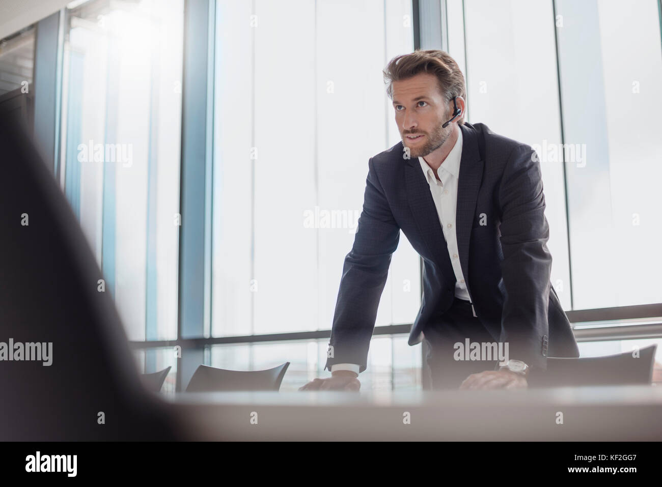 Portrait of businessman with bluetooth headset standing in conference room Stock Photo