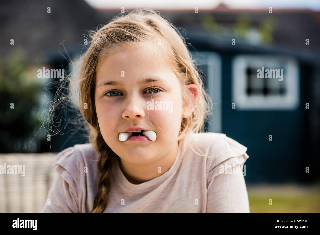 Girl with sweets in her mouth Stock Photo Alamy