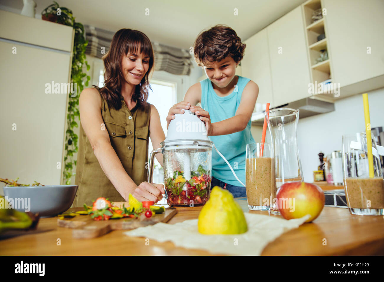 Son blending smoothie with mother Stock Photo