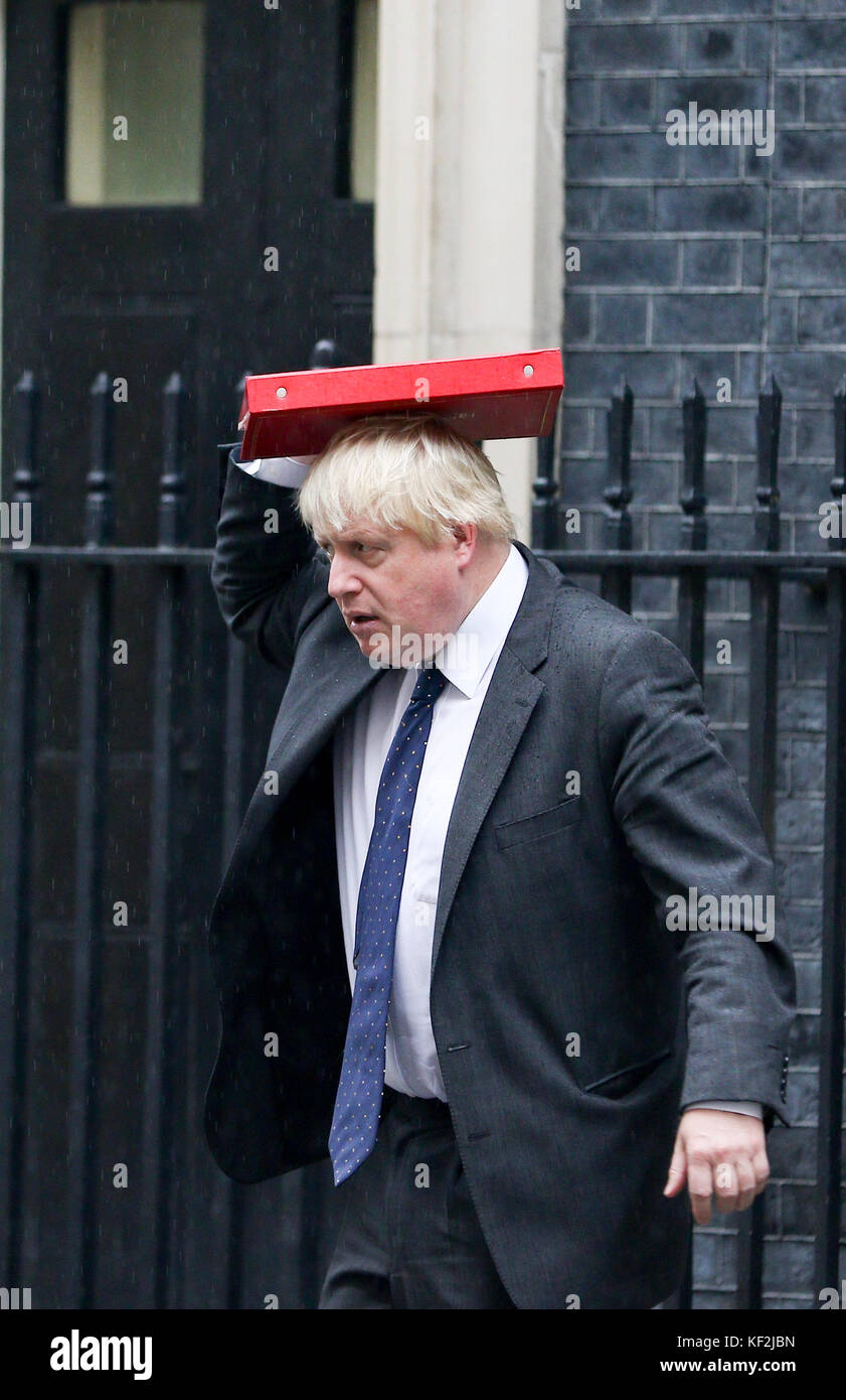 Foreign Secretary Boris Johnson leaving 10 Downing Street today covering his head from the rain with his Ministerial Red Folder. Stock Photo