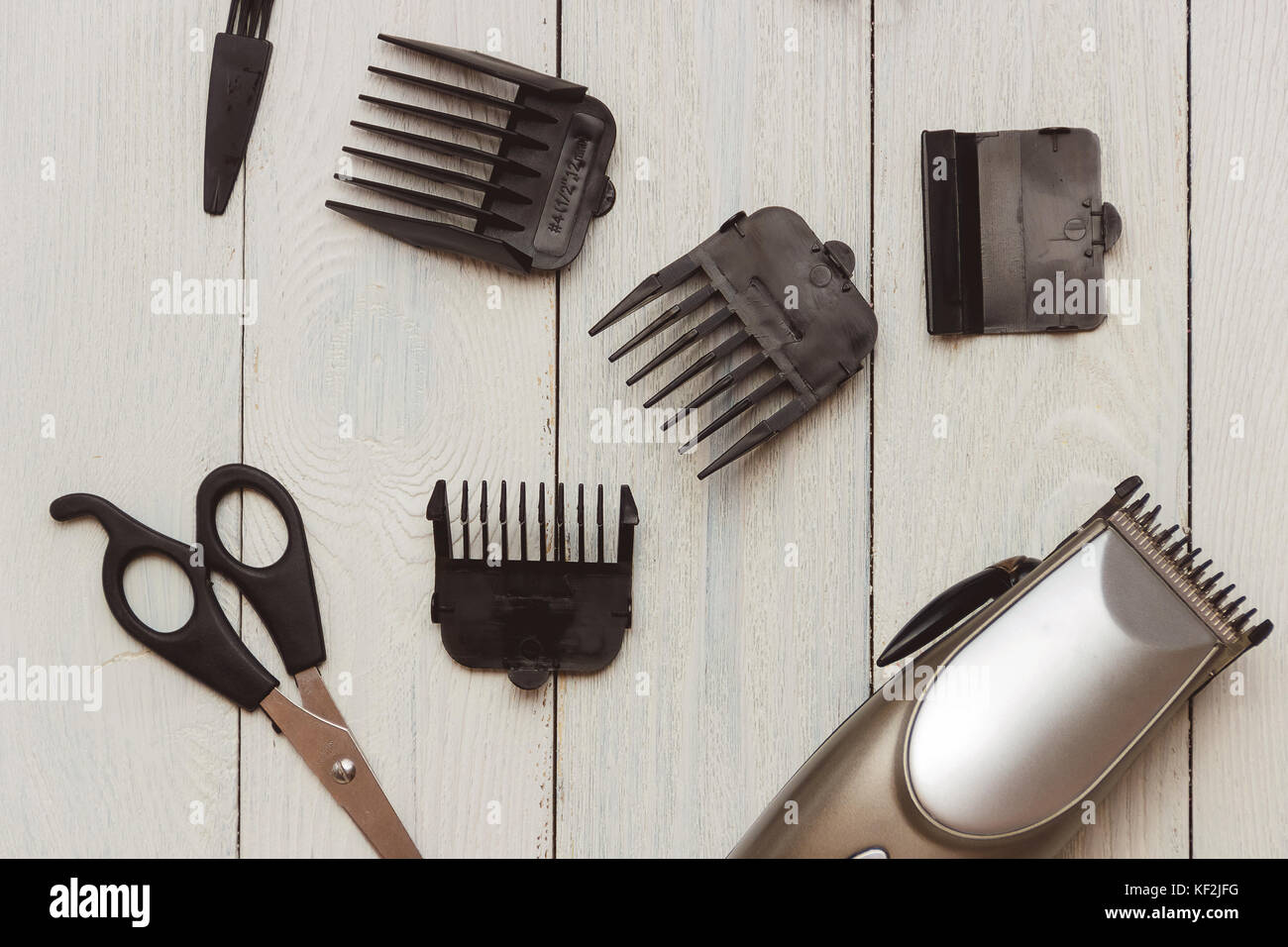 Stylish Professional Hair Clippers, accessories on wood background