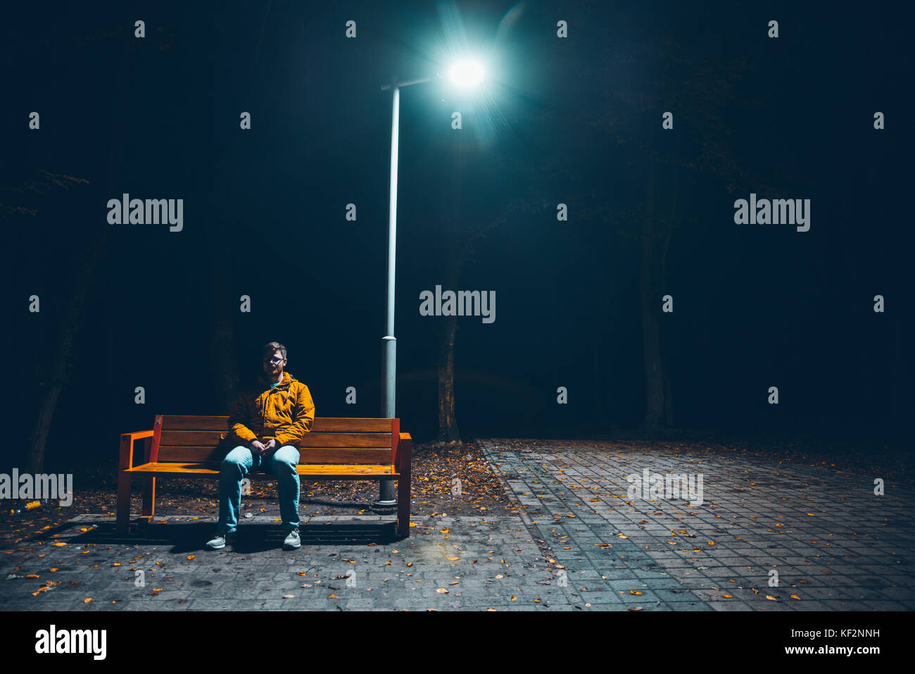 mad man sitiing on the banch in the dark Stock Photo - Alamy