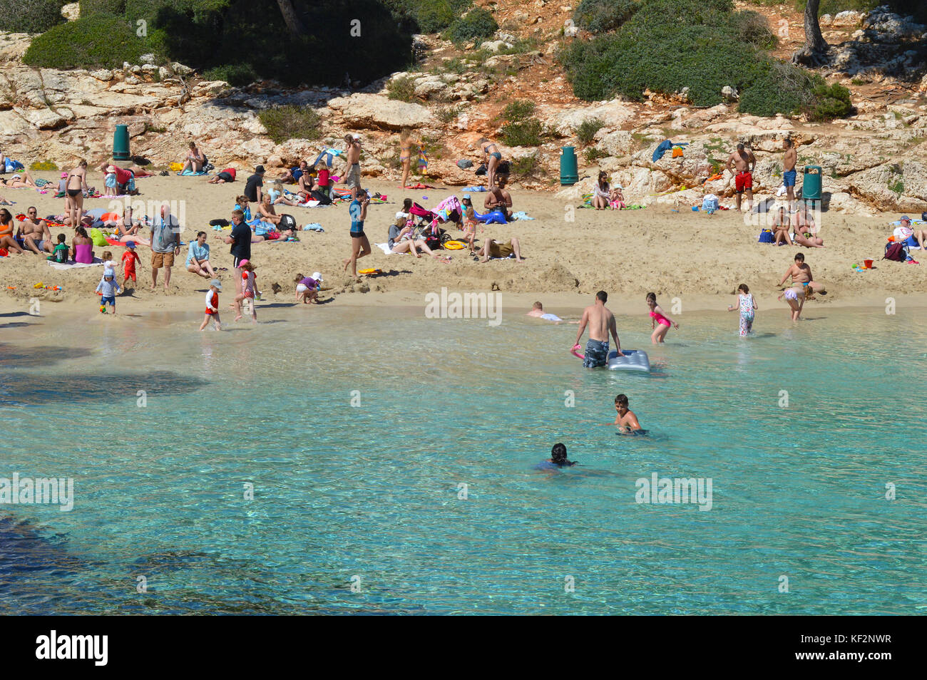 Holiday makers having fun on the beach at Cala Esmerelda Stock Photo