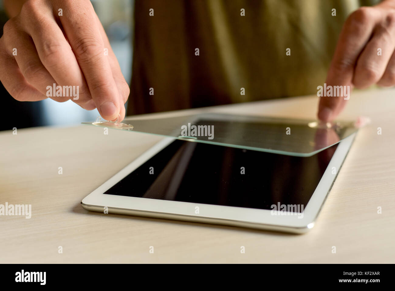closeup of a young caucasian man installing a screen protector in a digital tablet Stock Photo