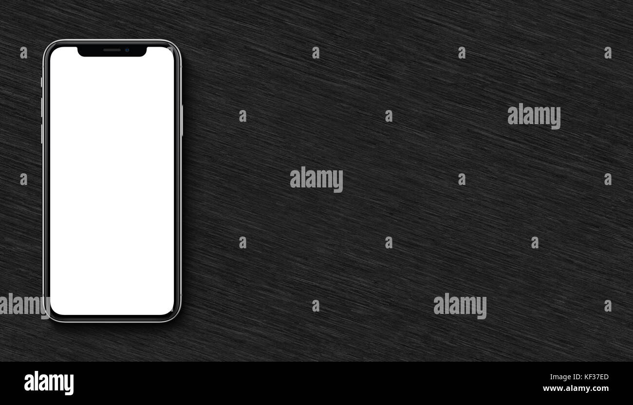 Smartphone similar to iPhone X mockup flat lay top view lying on black wooden office desk. Banner with copy space. Stock Photo