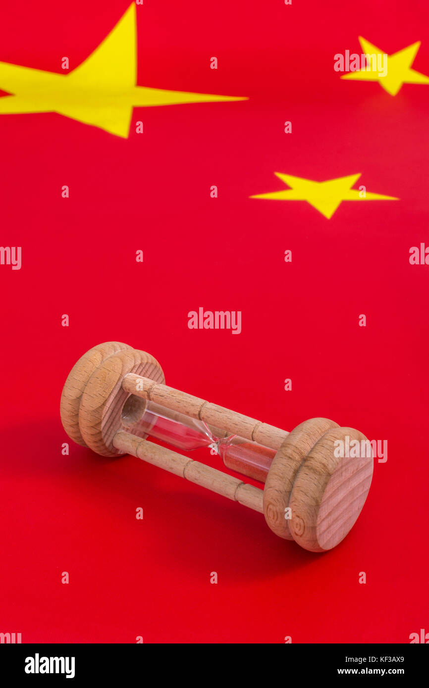 Chinese flag with small egg timer - metaphor for Chinese growing debt problem / crisis and time running out on financial problems, China debt crisis. Stock Photo