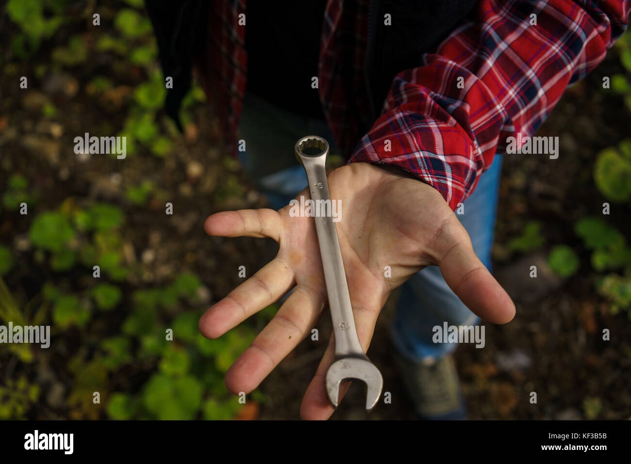 Close up hands of professional young mechanic man holding wrench. Auto