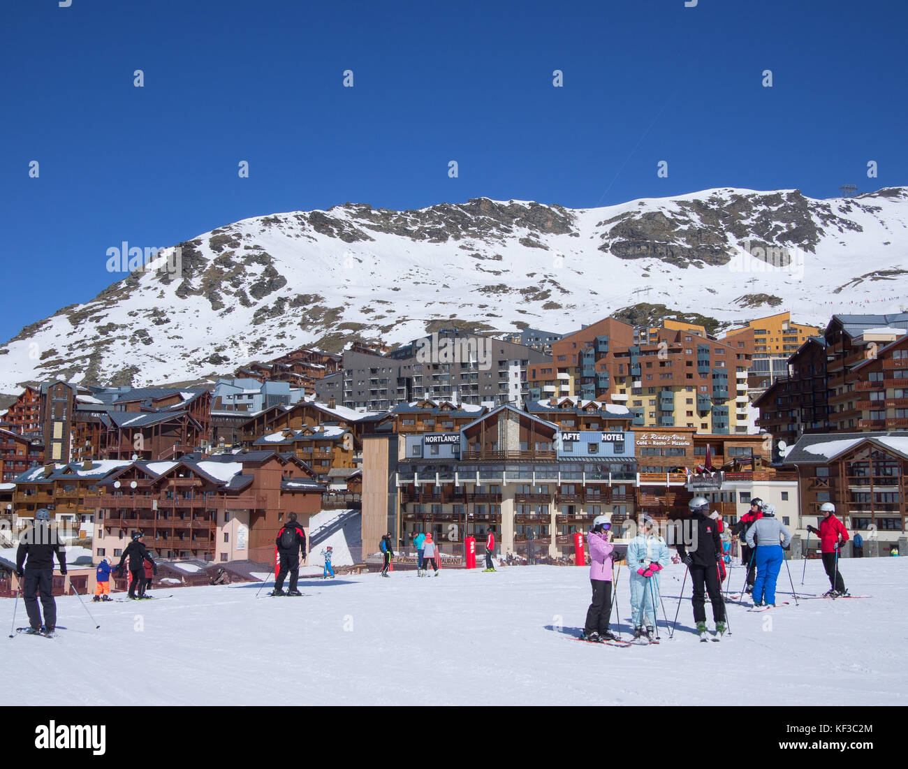 Val Thorens, France   March  18, 2017: people on the ski slopes in the center of the mountain village in a blue sky day Stock Photo