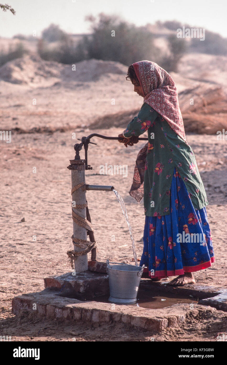 Pumping water from a hand pump in the Cholistan Desert near Utch, the Punjab, Pakistan. Stock Photo