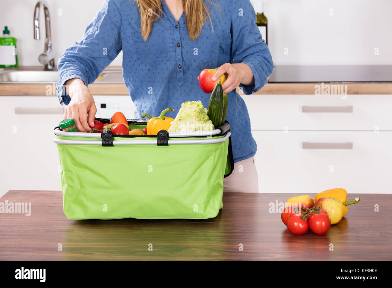 Close-up Of Woman Hand Removing Vegetable From Grocery Bag In Kitchen Stock Photo