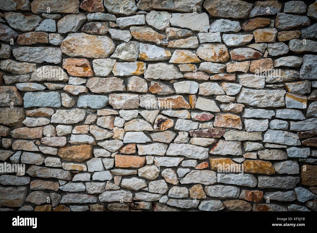 Stone wall background of colorful stones with vignetted borders Stock