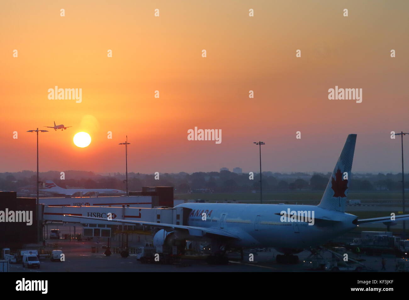 A plane landing at sunrise at London Heathrow Airport, UK Stock Photo